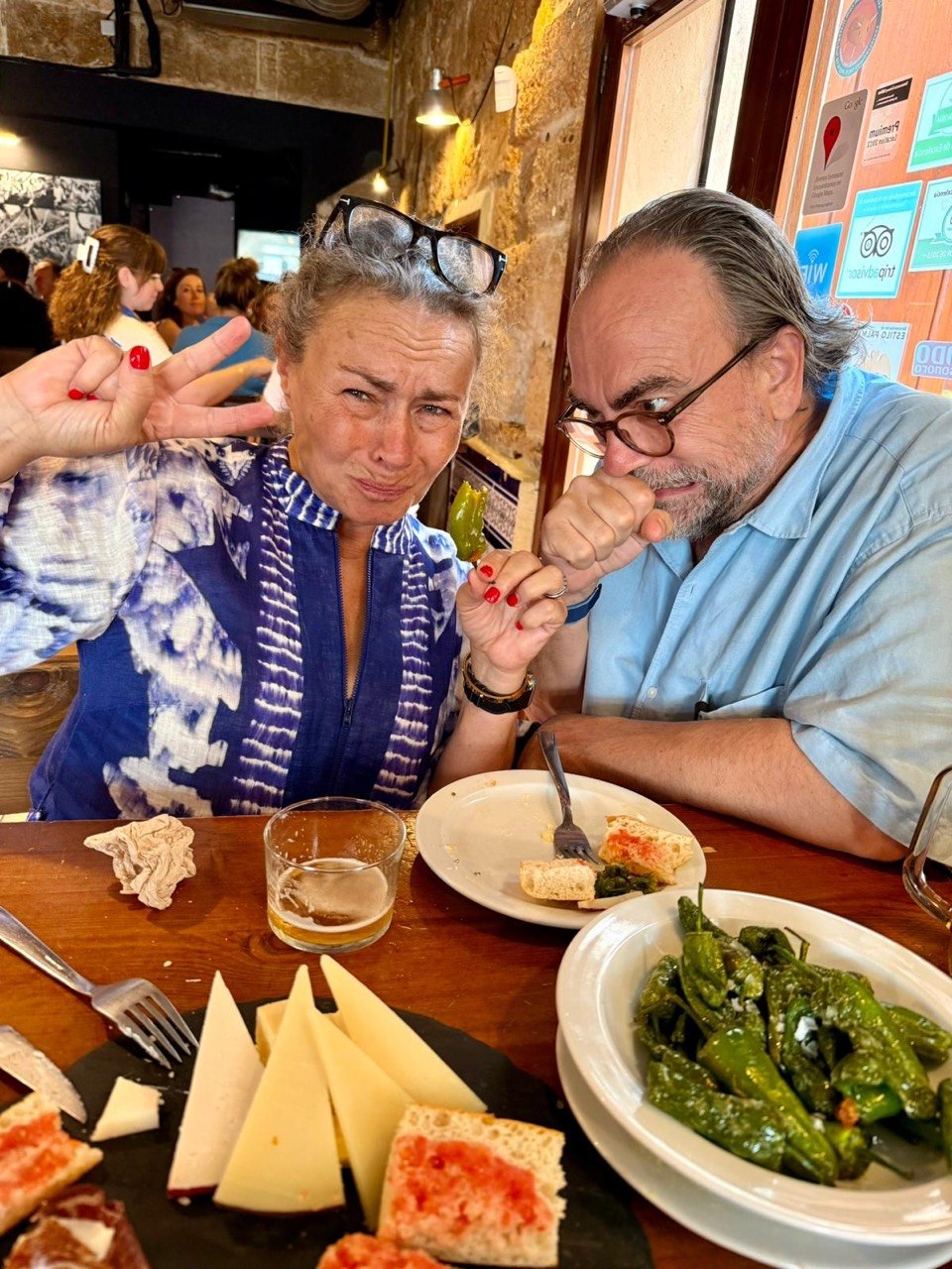 Kattis and JJ react after biting into an unexpectedly hot Padrón pepper at Bar Espanya.
